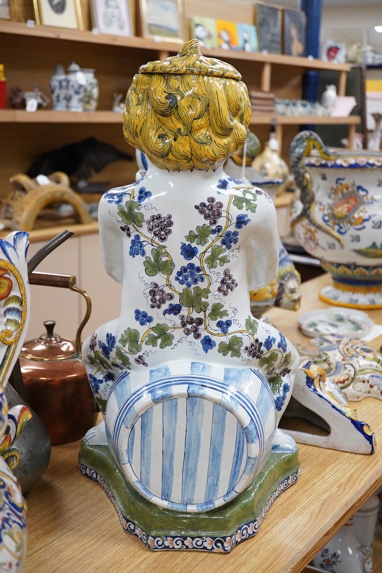 A large Brussels style faience Bacchus figural wine cistern, 62cm high